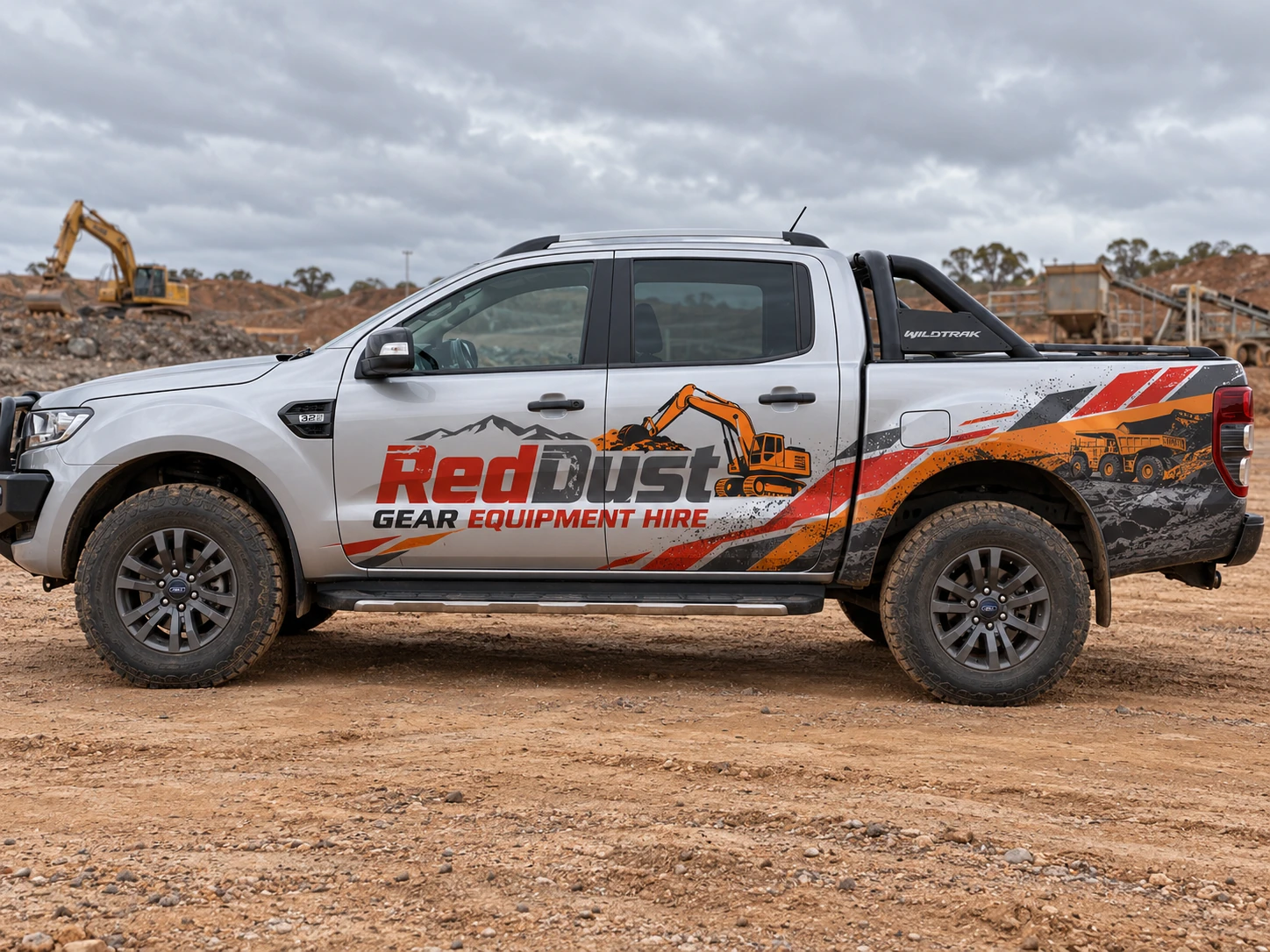 Silver Ford Ranger Wildtrak showing Red Dust Gear Equipment Hire vehicle graphics in a quarry setting